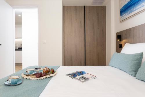 a bed with a bowl of fruit and a plate of food at Hestia - Asklipiou 9 in Athens