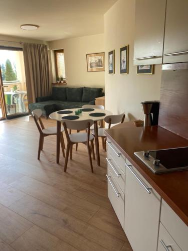 a kitchen and living room with a table and chairs at Apartament Przy Plaży in Władysławowo