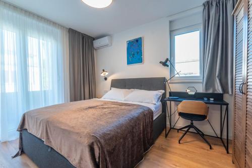 Split Luxury Suite 2 في سبليت: غرفة نوم بسرير ومكتب ونافذة