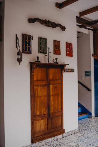 a room with a wooden door and some pictures on the wall at Hotel Casa Alquimia in Quito
