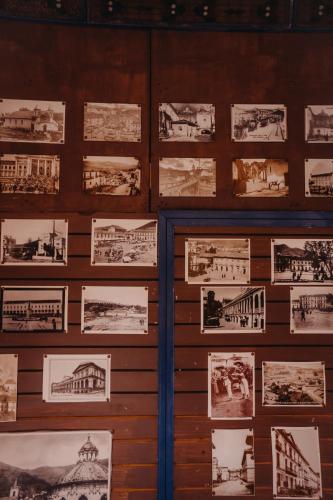 a wall with pictures of buildings on it at Hotel Casa Alquimia in Quito