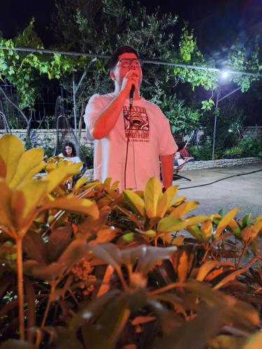 a man standing in front of a microphone at Oasis Hostel in Himare