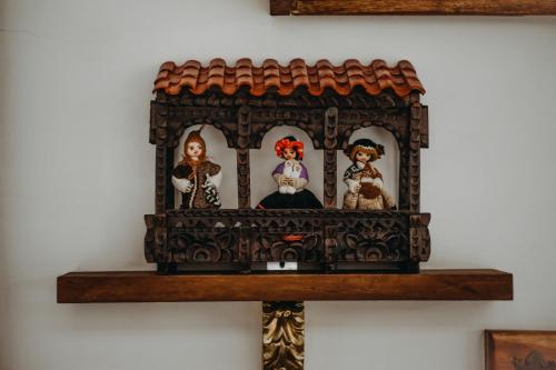 a wooden doll house with three dolls on a shelf at Hotel Casa Alquimia in Quito