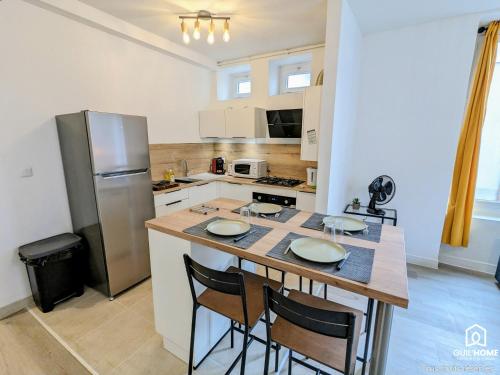 Il dispose d'une cuisine avec un îlot pourvu de chaises et d'un réfrigérateur. dans l'établissement Le Saint-Loup - Parking - Plain-pied - Central, à Orléans