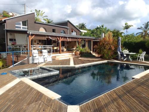 a swimming pool in front of a house at Villa Le Coin de Paradis in Saint-Leu