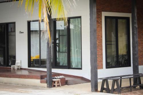a house with windows and a bench on the porch at FineUpHome บ้านพักเหมาหลัง 3 ห้องนอน 2 ห้องน้ำ ห้องครัว ห้องรับแขก ห้องรับประทานอาหาร พร้อมสระว่ายน้ำส่วนตัว in Chiang Khan