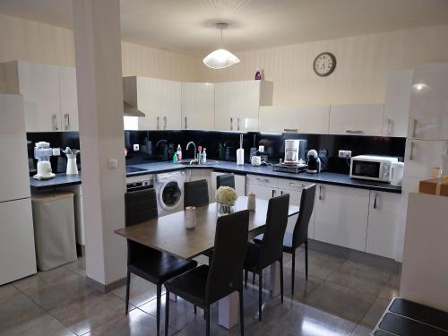 une cuisine avec une table et des chaises et un micro-ondes dans l'établissement Appartement Gournay-sur-Marne, à Gournay-sur-Marne