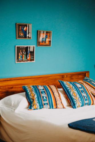 a bedroom with a blue wall and a bed with pillows at Hotel Casa Alquimia in Quito