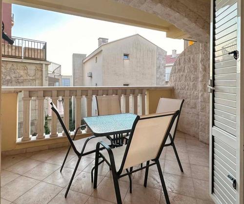 a patio with a table and chairs on a balcony at Beach Bliss Apartment in Pržno