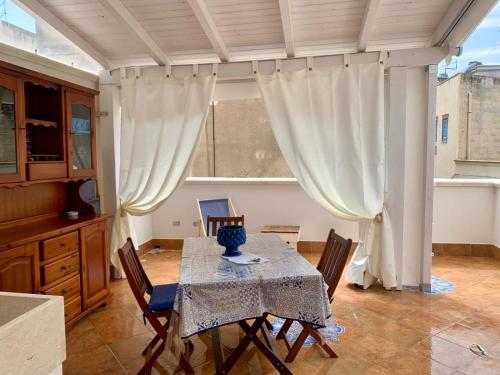 a dining room with a table and chairs and a window at le calette Marettimo in Marettimo