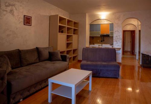 a living room with a couch and a table at Beach Bliss Apartment in Pržno