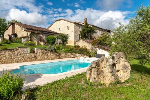 - une piscine en face d'une maison en pierre dans l'établissement La Maison de Yûka, à Plieux