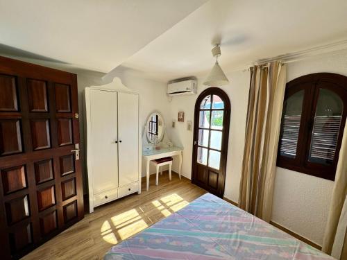 a bedroom with a bed and a desk and a door at Excelent Chalet Triplex in Kasr Rimal-Kabila Tetouan in M'diq