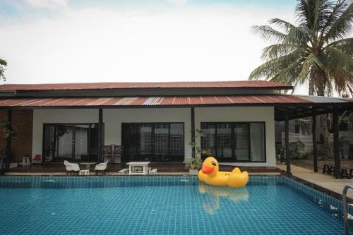 a pool with a rubber ducky in front of a house at FineUpHome บ้านพักเหมาหลัง 3 ห้องนอน 2 ห้องน้ำ ห้องครัว ห้องรับแขก ห้องรับประทานอาหาร พร้อมสระว่ายน้ำส่วนตัว in Chiang Khan