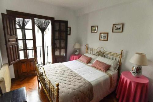 sypialnia z dużym łóżkiem z dwoma stołami w obiekcie Casa Rural El Mirador del Pico w mieście Santa Cruz del Valle