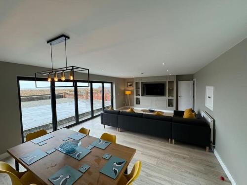 a living room with a table and a couch at Bungalow on the beach in South Hayling