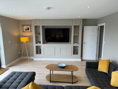a living room with a couch and a table at Bungalow on the beach in South Hayling