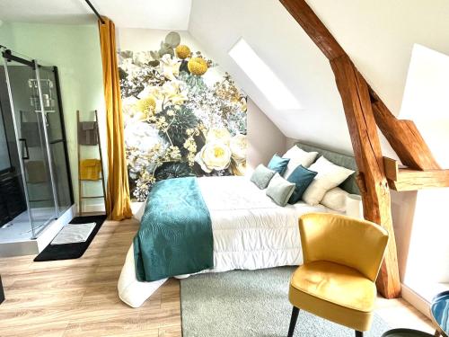 ein Schlafzimmer mit einem Bett und einem gelben Stuhl in der Unterkunft Le Clos des Roses in Meusnes