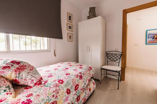 a bedroom with a bed and a chair at Precioso Chalet Atlántida solo familias in Roche