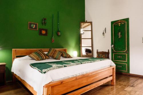 a bedroom with a bed with a green wall at Hotel Casa Alquimia in Quito