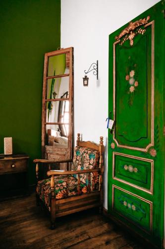 a green room with a chair and a dresser at Hotel Casa Alquimia in Quito