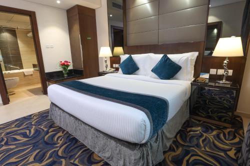 a hotel room with a large bed and a bathroom at Omega Hotel Dubai in Dubai