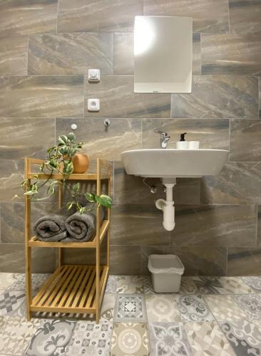 a bathroom with a sink and a shelf with towels at Resort Konírna in Mikulov