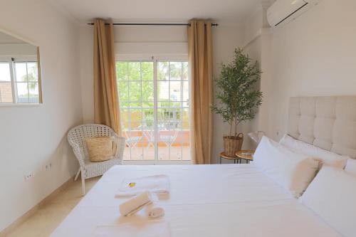 a bedroom with a white bed and a window at Maravilloso adosado para 8 en entorno privilegiado by Hometels in Canet de Berenguer