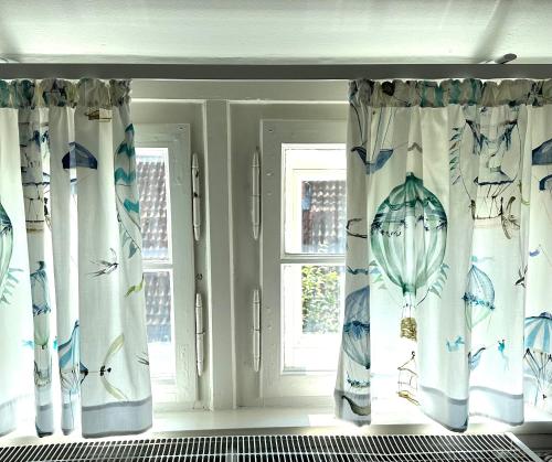 a room with curtains with drawings of birds on them at Remedium Appartements in Vlotho