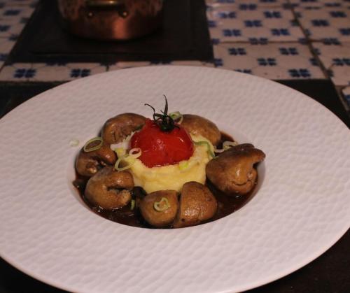 a plate of food with mushrooms and a tomato on it at La Maison TATIN in Lamotte-Beuvron
