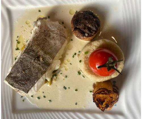 a plate of food with a sandwich and a tomato at La Maison TATIN in Lamotte-Beuvron