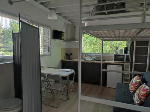 Zimmer mit einem Hochbett mit einem Tisch und einer Küche in der Unterkunft Studio meublé 1 pièce entièrement équipé sans cloisons séparatives in Chavagnes-en-Paillers