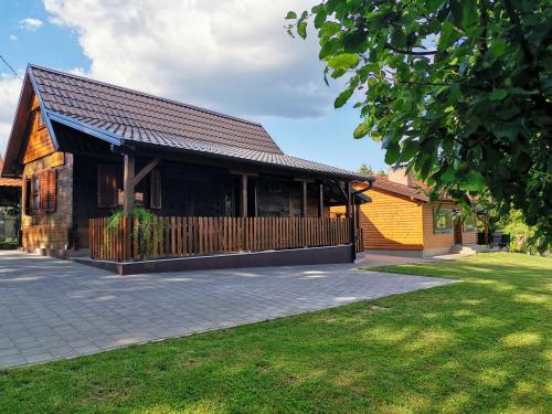 a building with a fence in front of a yard at Kuća za odmor Šumska idila in Velika Gorica