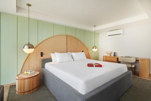 - une chambre avec un grand lit blanc et un bureau dans l'établissement Wellcomm Spa & Hotel, à Medellín
