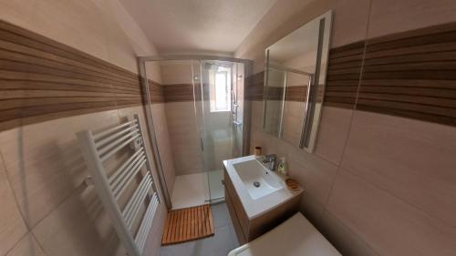 une petite salle de bain avec un lavabo et un miroir dans l'établissement LeWindy Barcares Terrasse Confort Calme Fibre Vélos Bord Lac Proximité Plage Lydia Coudalere, au Barcarès