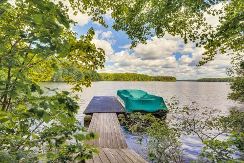 a boat sitting on a dock on a lake at Lakefront Roxboro Home with Private Dock! in Roxboro