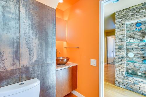 a bathroom with orange walls and a sink and a toilet at Lakefront Roxboro Home with Private Dock! in Roxboro