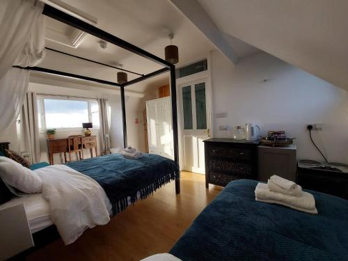 a bedroom with two beds and a table and a window at Pilgrims of the Goddess in Glastonbury