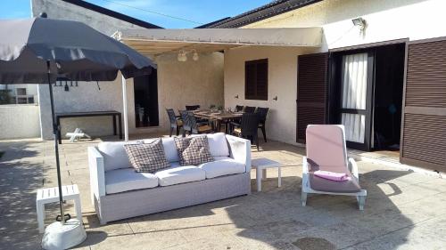 a couch and a chair and an umbrella on a patio at GuestReady - Casa do Farol in Marinhas