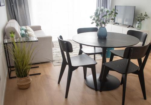 a dining table and chairs in a living room at Stylish 2 Bed 2 Bath Apt in St Julians in St. Julianʼs