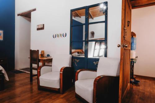 a living room with two chairs and a table at Hotel Casa Alquimia in Quito