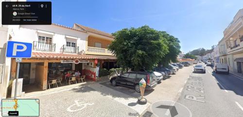 ulica z samochodami zaparkowanymi przed budynkiem w obiekcie Casinhas Proença - Family w Aljezur
