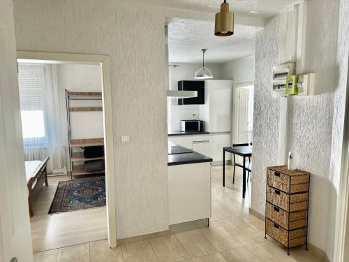 une cuisine avec des placards blancs et une salle à manger dans l'établissement F4 meublé, à Wittenheim