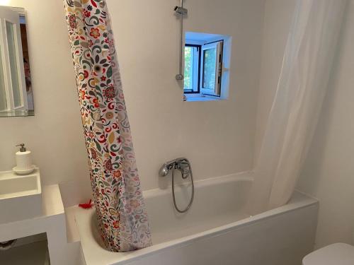 a bath tub with a shower curtain in a bathroom at Metropolis Villa in Vathi, Ithaka
