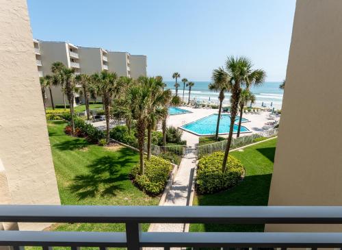 a view of the beach from the balcony of a resort at Coastal condo with beachfront views and pool access! in New Smyrna Beach