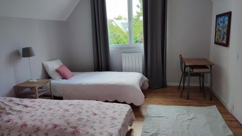 ein kleines Zimmer mit 2 Betten und einem Fenster in der Unterkunft Le clos Saint Denis in Saint-Denis-en-Val