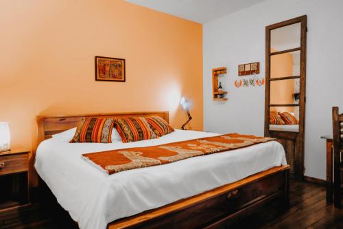 a bedroom with a large bed with white sheets at Hotel Casa Alquimia in Quito
