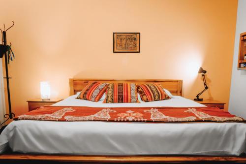 a bedroom with a bed with a blanket on it at Hotel Casa Alquimia in Quito