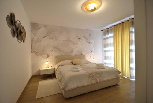 - une chambre avec un lit orné d'une fresque murale dans l'établissement Magnolia, à Opatija