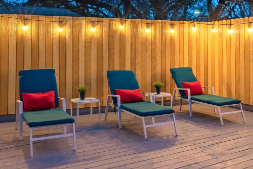 four chairs with red pillows sitting on a deck at Pool, Gameroom & Minigolf Enchanting Texas Home in San Antonio